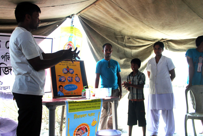 Boat Clinic Community worker demonstrating hand washing to a child
