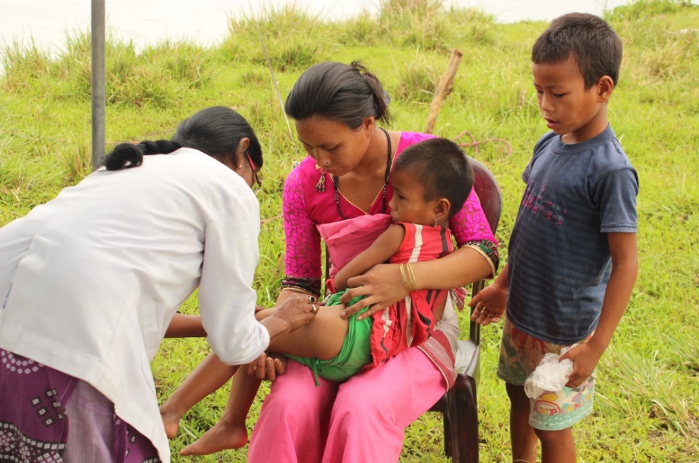 Damayanti Das, an Auxiliary Nursing Midwife who has been with C-NES’s Dibrugarh Boat Clinic since 2008, effortlessly gives a child a required vaccination